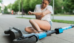 Junge Frau nach Sturz vom E-Scooter