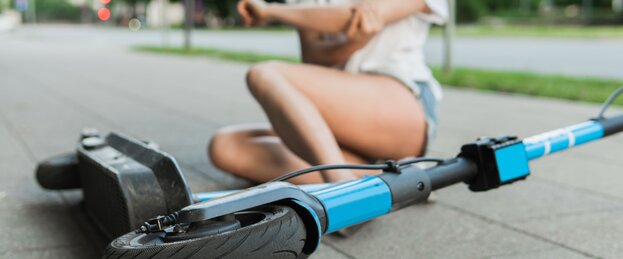 Junge Frau nach Sturz vom E-Scooter