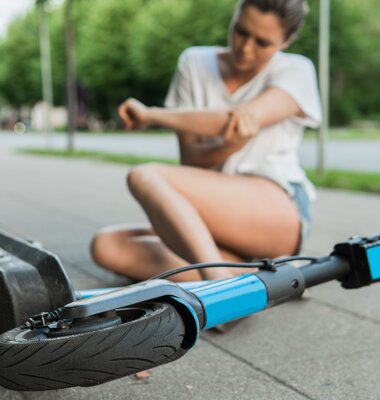 Junge Frau nach Sturz vom E-Scooter