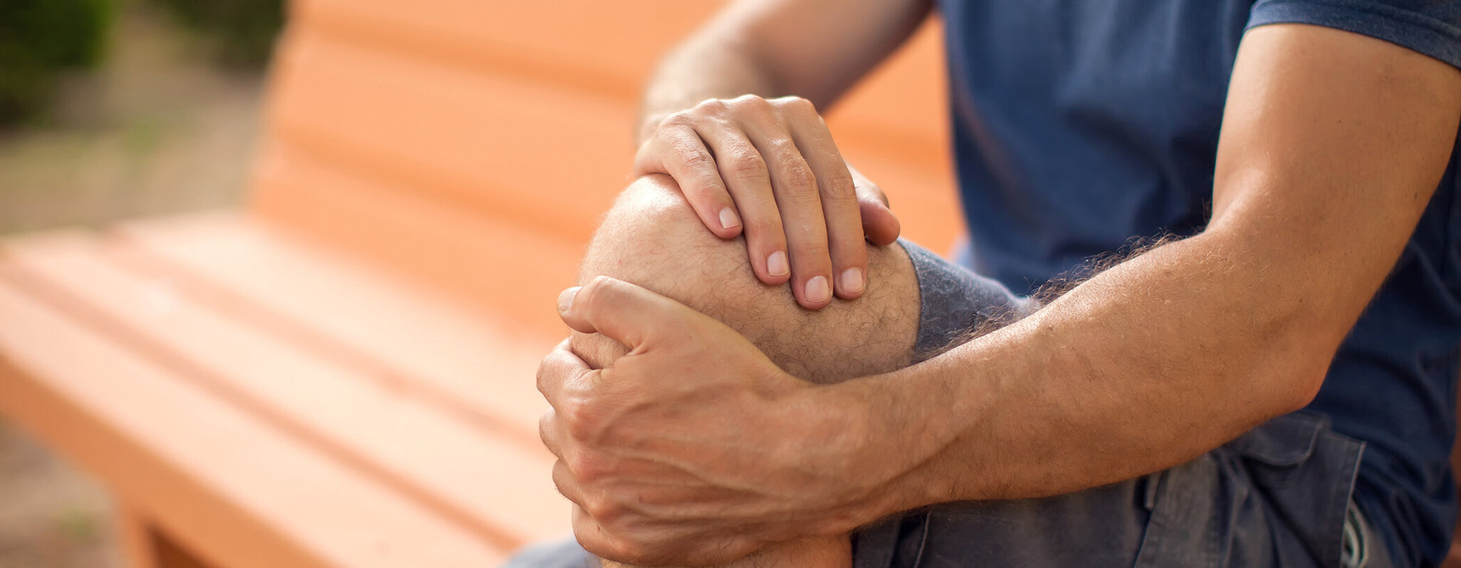 Mann fasst sich an das schmerzende Knie