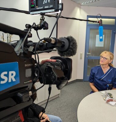 Kamera des Saarländischen Rundfunks und Interviewpartnerin des UKS