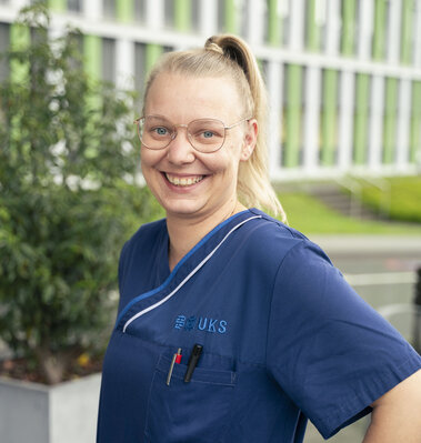 Pflegefachkraft vor Klinikgeb&auml;ude