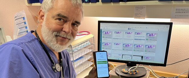 Prof. Dr. Arne Simon mit der TeleKasper-App am Smartphone und am PC