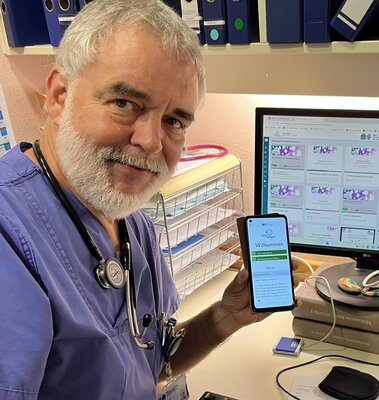 Prof. Dr. Arne Simon mit der TeleKasper-App am Smartphone und am PC
