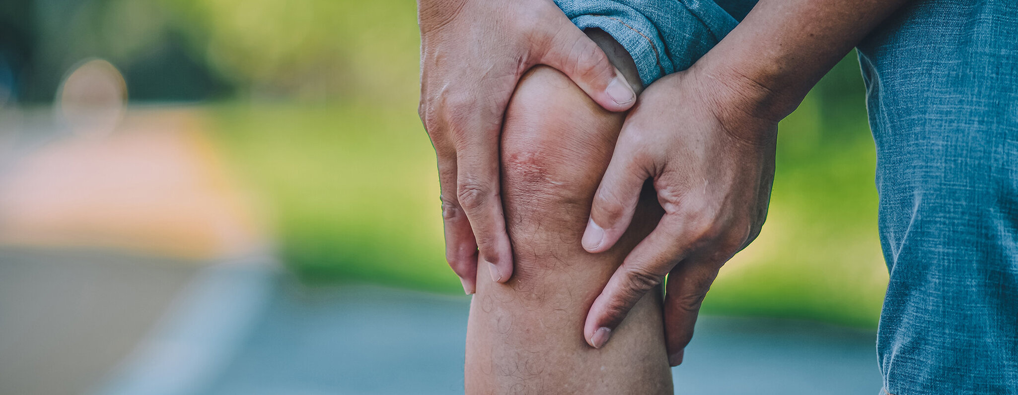 Mann fasst sich an das schmerzende Knie