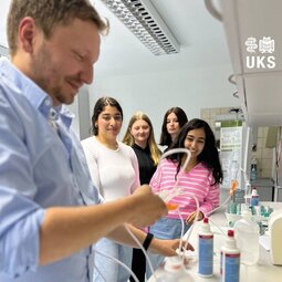 Vier M&auml;dchen schauen dabei zu, wie eine Infusion gerichtet wird