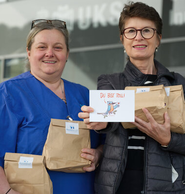 Anja Becker und Christine Pack mit einer Grußkarte des Vereins Eisvogel